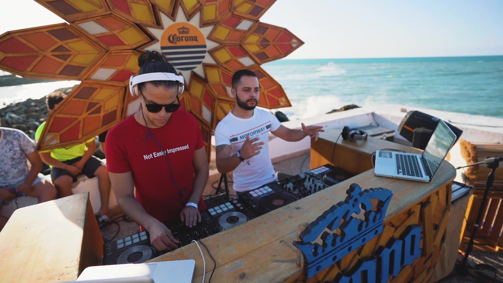 DJs playing in front of the sea