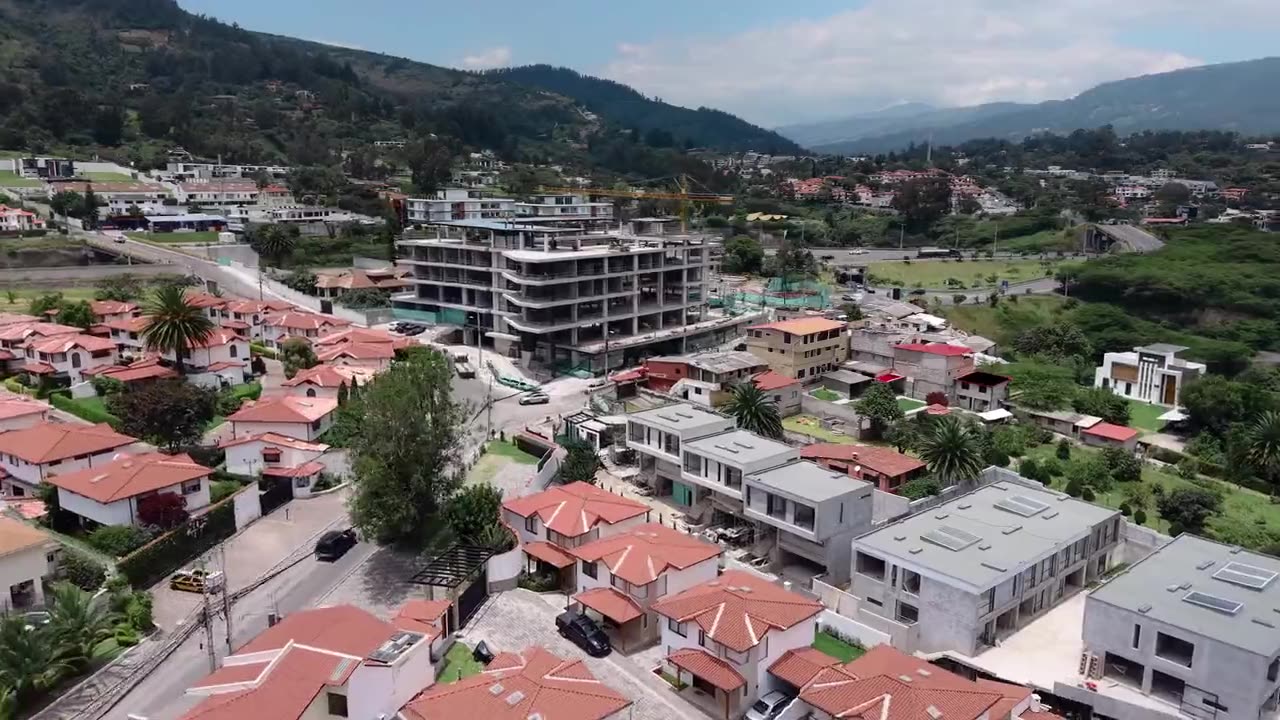 Barrio residencial y edificios del valle vistos desde el dron, con las montañas al fondo