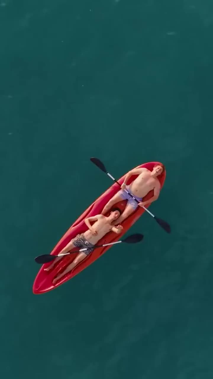 Kayak rojo sobre agua turquesa visto desde arriba