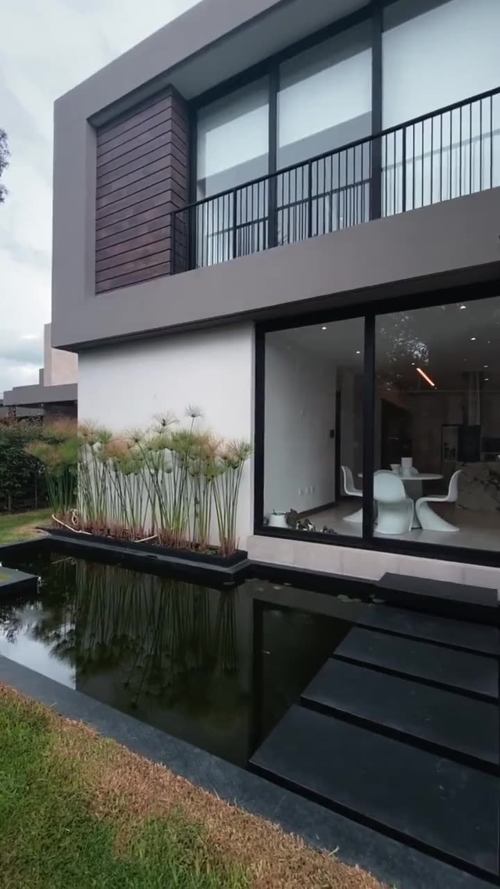 Fachada de la casa con el espejo de agua